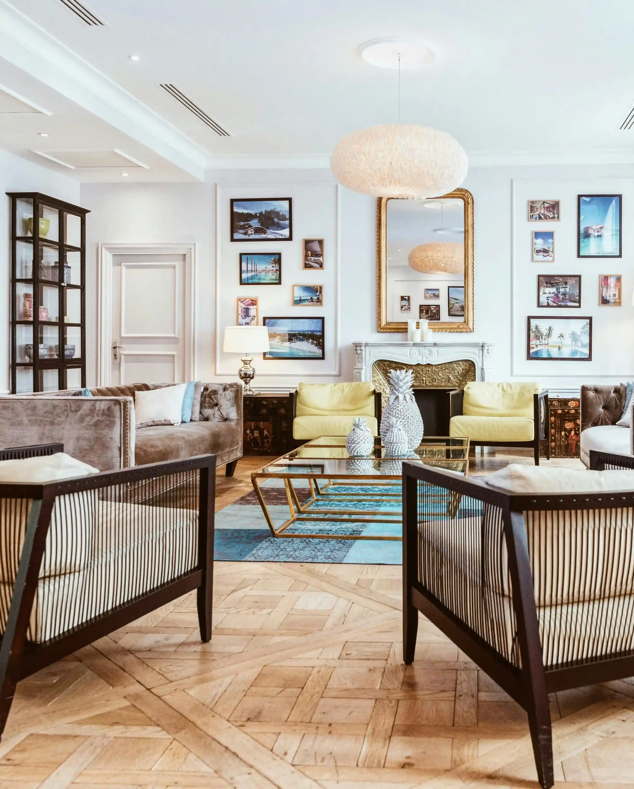 Stylish living room with yellow chairs, glass coffee table, framed art, and fireplace.